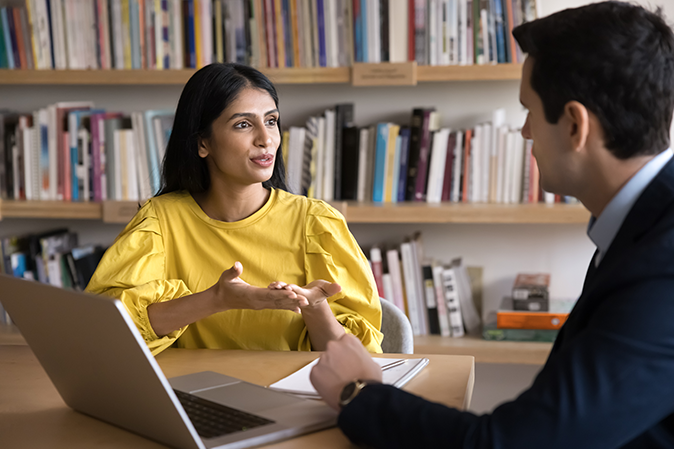 Tutoring service. Confident millennial female teacher tutor academic advisor support consult young male university student at campus library mentoring in planning course schedule discuss career goals