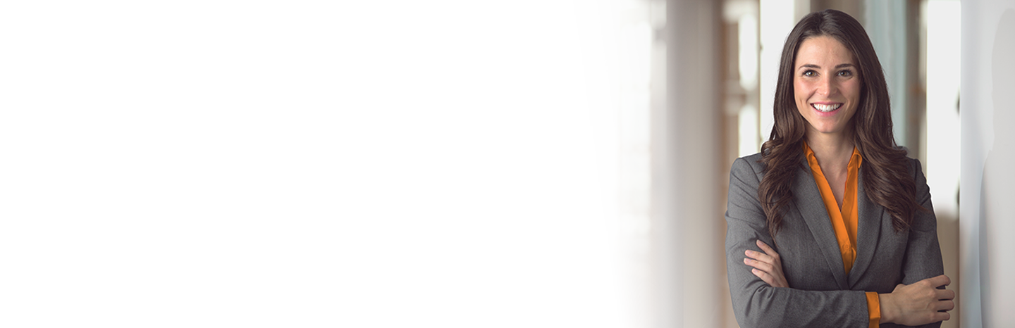 Young woman smiling with arms crossed dressed in a business suit