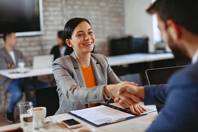 Young woman shaking hands with a man in the office