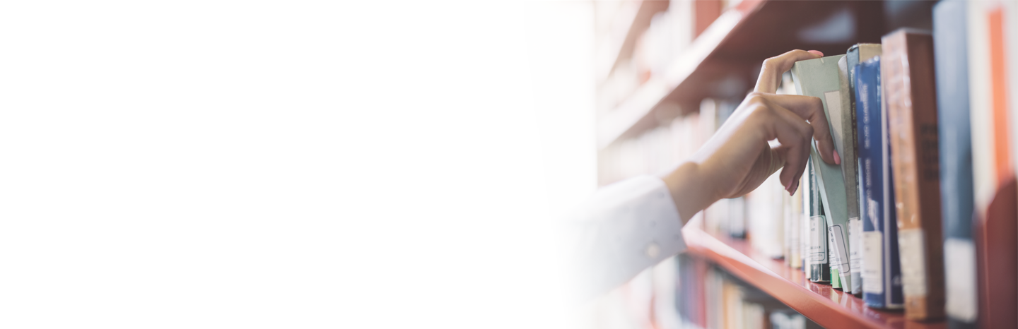 Woman pulling a book off a shelf in a library